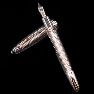 Montblanc Meisterstuck 146 Solitaire Geometry City Edition LeGrand Fountain Pen - New York laying on top of its cap in a crossed position showing full view of the entire uncapped pen.
