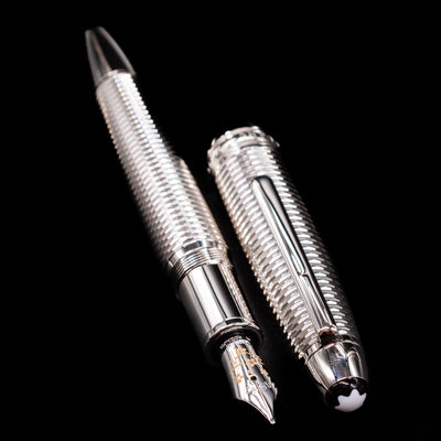 A full view of the Montblanc Meisterstuck 146 Solitaire Geometry City Edition LeGrand Fountain Pen - Tokyo uncapped, with its cap laying next to the pen. 