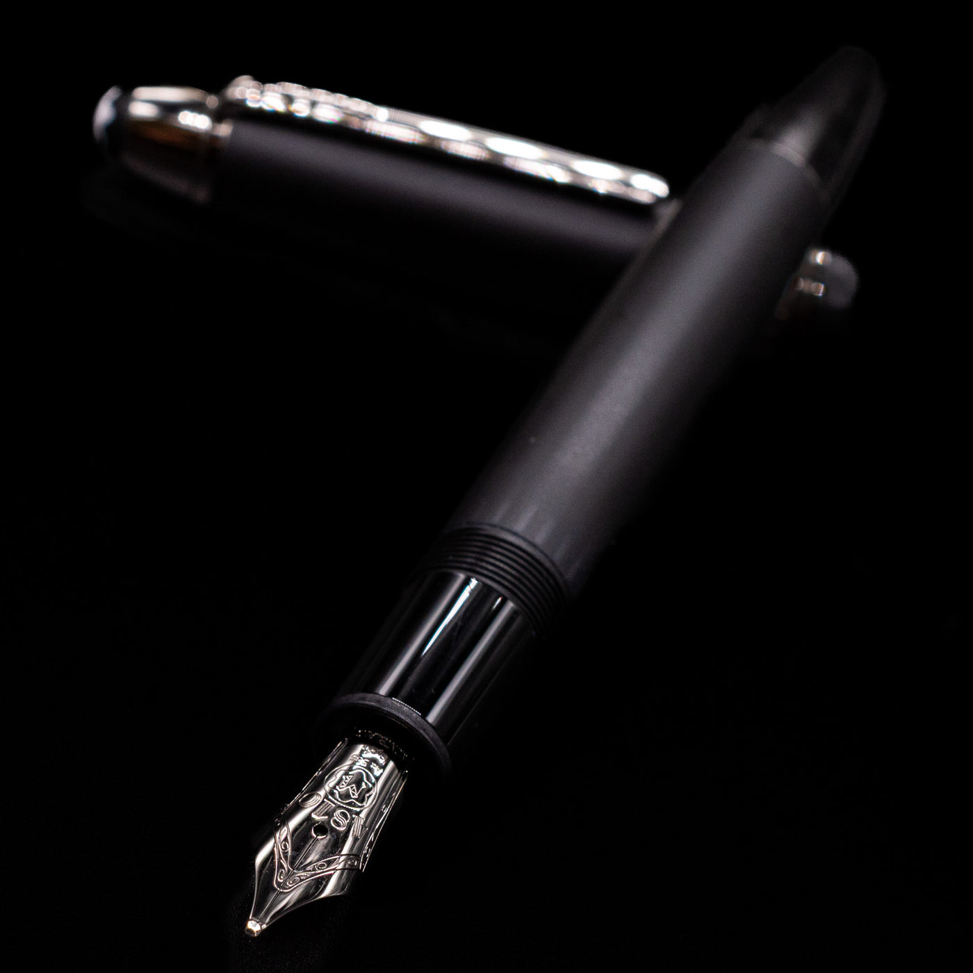 Montblanc Meisterstuck 146 Ultra Black LeGrand Fountain Pen - Preowned laying across its own cap, crossed, with a focus on the nib.