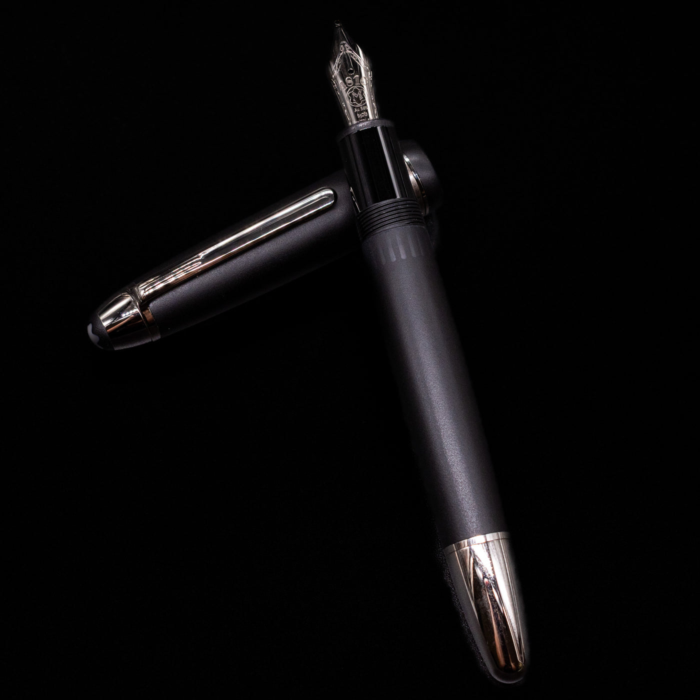 Montblanc Meisterstuck 146 Ultra Black LeGrand Fountain Pen - Preowned laying on top of its cap in a crossed position showing full view of the entire uncapped pen.