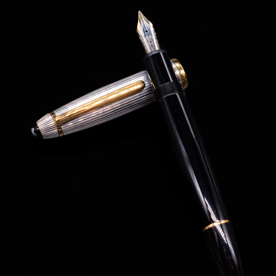 Montblanc Meisterstuck 147DS Solitaire Doue Traveler Fountain Pen - Preowned laying on top of its cap in a crossed position showing full view of the entire uncapped pen.