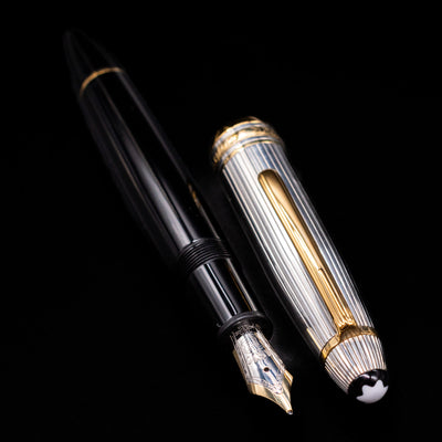 A full view of the Montblanc Meisterstuck 147DS Solitaire Doue Traveler Fountain Pen - Preowned uncapped, with its cap laying next to the pen. 