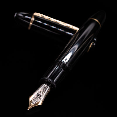 Preowned Montblanc Meisterstück 149 fountain pen and cap crossed, with focus on the detailed engravings of the large gold nib and the pen’s polished black resin finish.