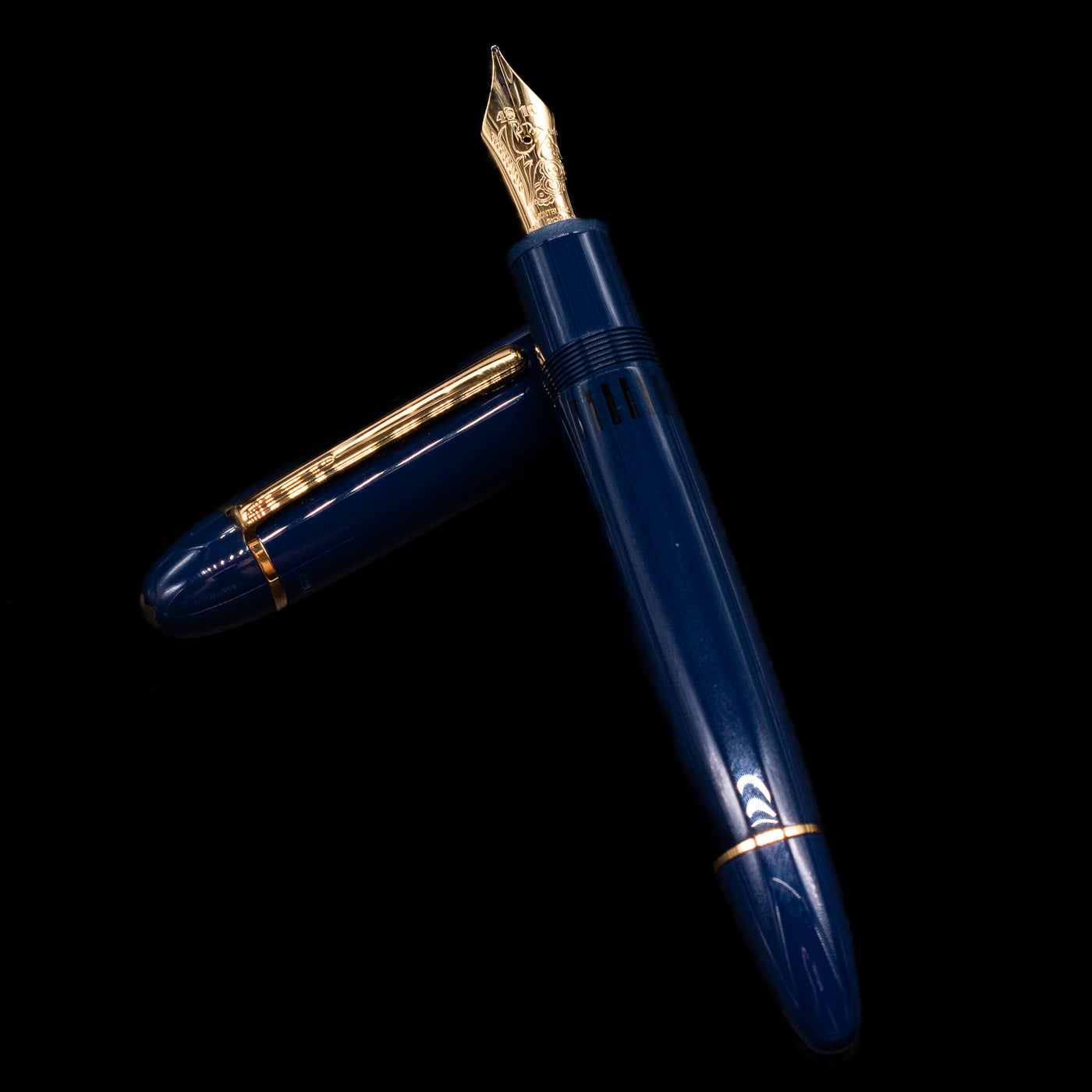Montblanc Meisterstuck 149 Orient Express Limited Edition 1883 Fountain Pen - Preowned laying on top of its cap in a crossed position showing full view of the entire uncapped pen.