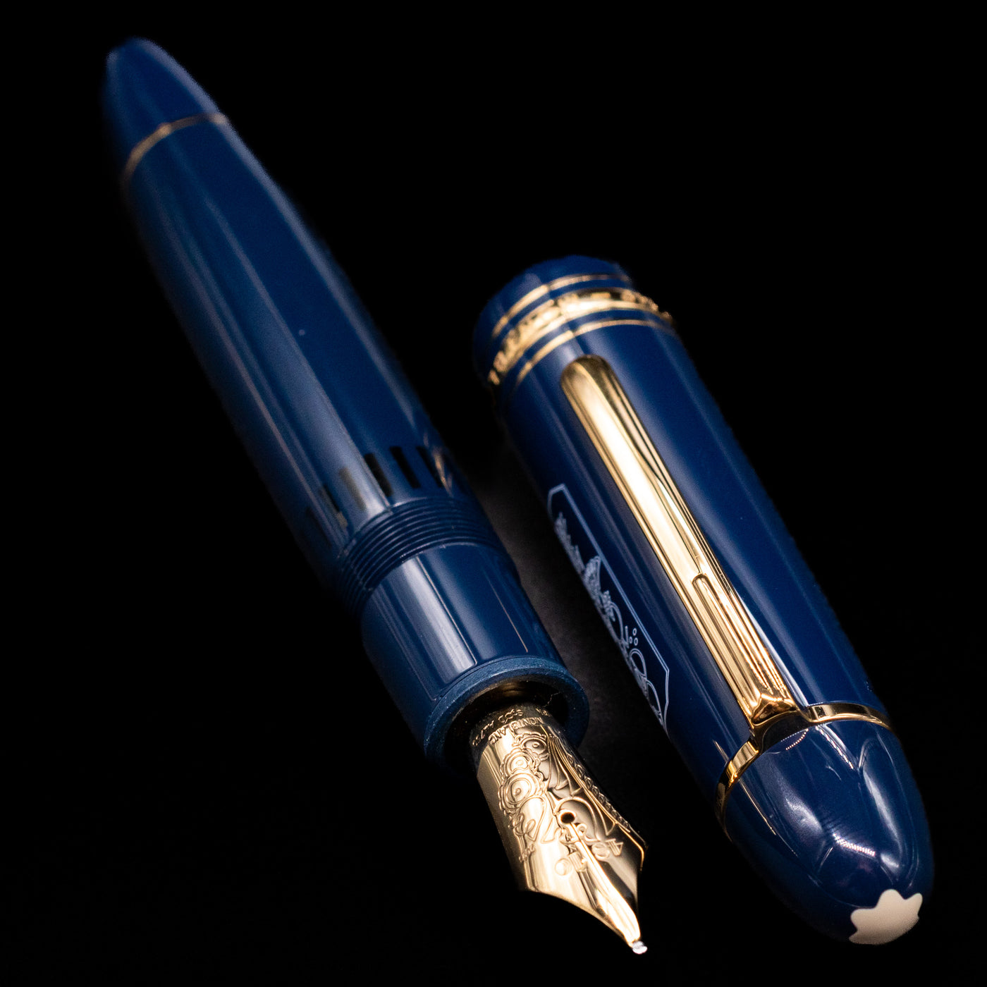 A full view of the Montblanc Meisterstuck 149 Orient Express Limited Edition 1883 Fountain Pen - Preowned uncapped, with its cap laying next to the pen. 