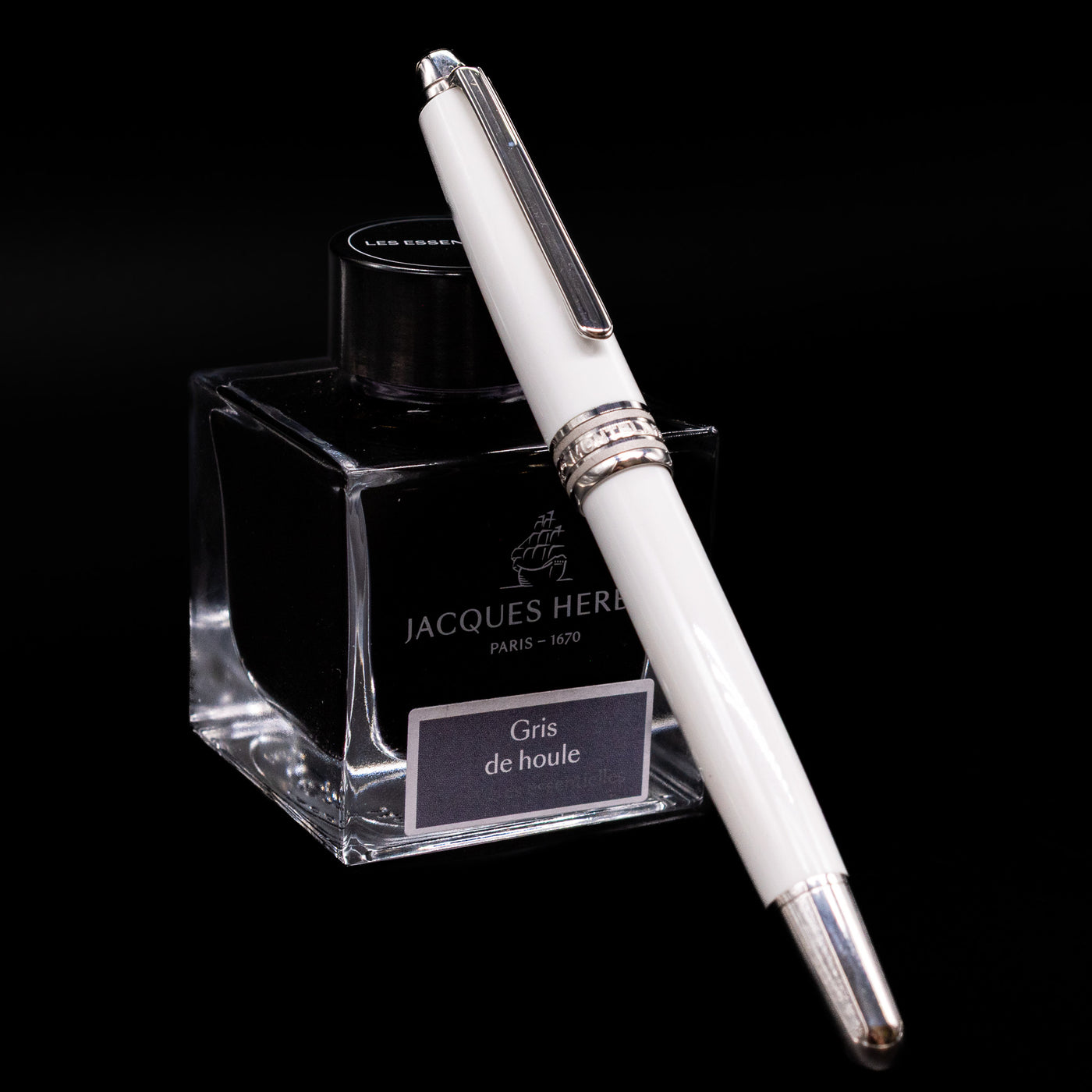 Preowned Montblanc Meisterstück 163 Solitaire Tribute to Mont Blanc rollerball pen shown capped, resting at an angle against an ink bottle.