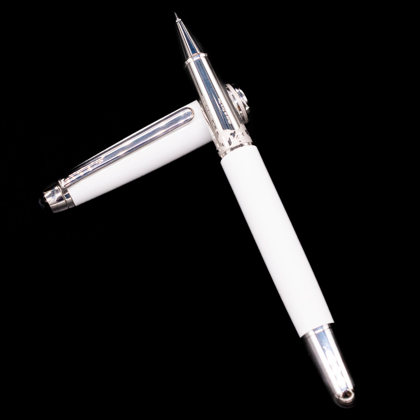Preowned Montblanc Meisterstück 163 Solitaire Tribute to Mont Blanc rollerball pen and cap arranged in a crossed position, showcasing the intricate detailing on the grip and the polished white barrel.