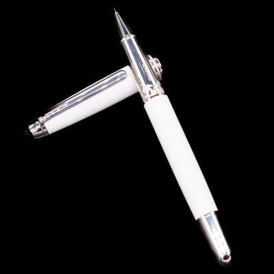 Preowned Montblanc Meisterstück 163 Solitaire Tribute to Mont Blanc rollerball pen and cap arranged in a crossed position, showcasing the intricate detailing on the grip and the polished white barrel.