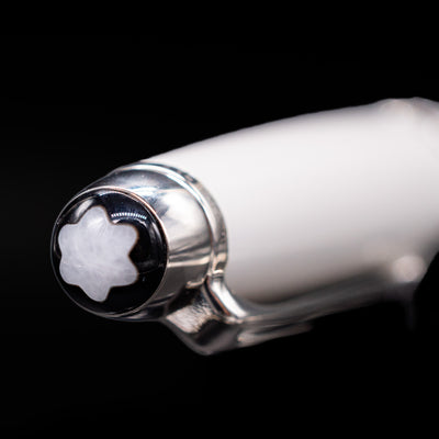 Close-up of the cap top on the preowned Montblanc Meisterstück 163 Solitaire Tribute to Mont Blanc rollerball pen, featuring the white Montblanc snowcap emblem set into the platinum-coated finial.