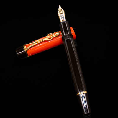 Montblanc Meisterstuck Donation Series Johann Sebastian Bach Fountain Pen - Preowned laying on top of its cap in a crossed position showing full view of the entire uncapped pen.