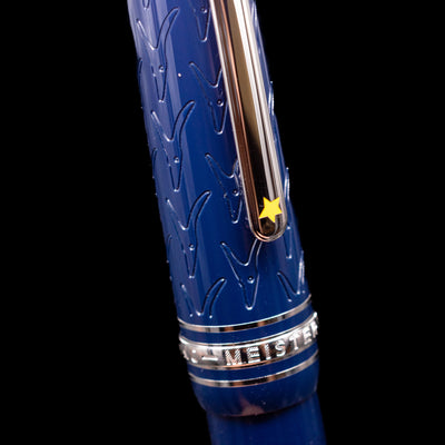 Close-up of the cap and clip of the preowned Montblanc Meisterstück Le Petit Prince Fox LeGrand fountain pen, focusing on the polished platinum-plated clip and the smooth blue resin cap surface.