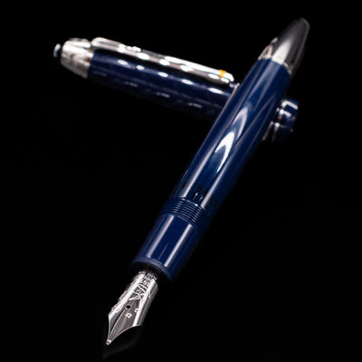 Preowned Montblanc Meisterstück Le Petit Prince Fox LeGrand fountain pen and cap crossed, with focus on the engraved nib and the polished platinum-plated trim.