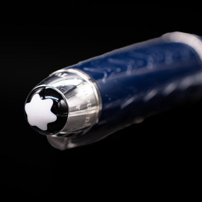 Close-up of the cap top on the preowned Montblanc Meisterstück Le Petit Prince Fox LeGrand fountain pen, featuring the white Montblanc snowcap emblem set into the glossy blue resin finial.