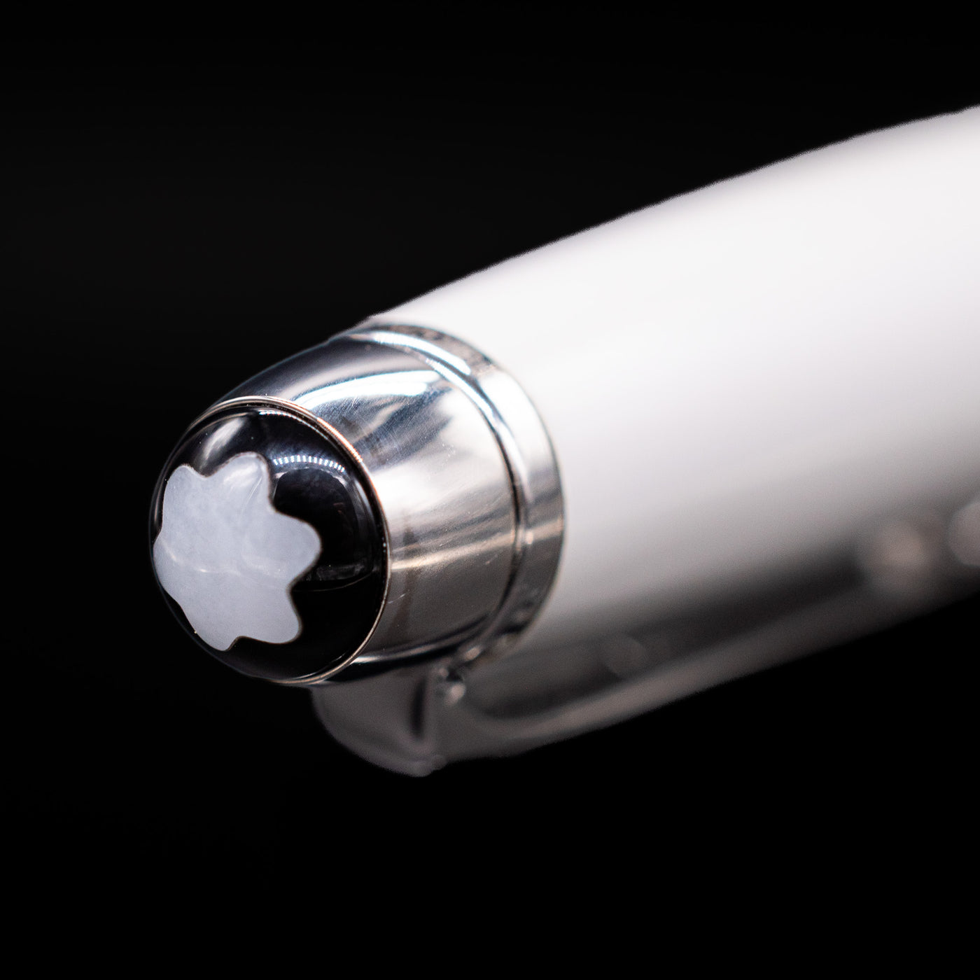 Close-up of the cap top on the preowned Montblanc Meisterstück Solitaire Tribute to Mont Blanc ballpoint pen, featuring the iconic white Montblanc snowcap emblem set into the platinum-coated finial.