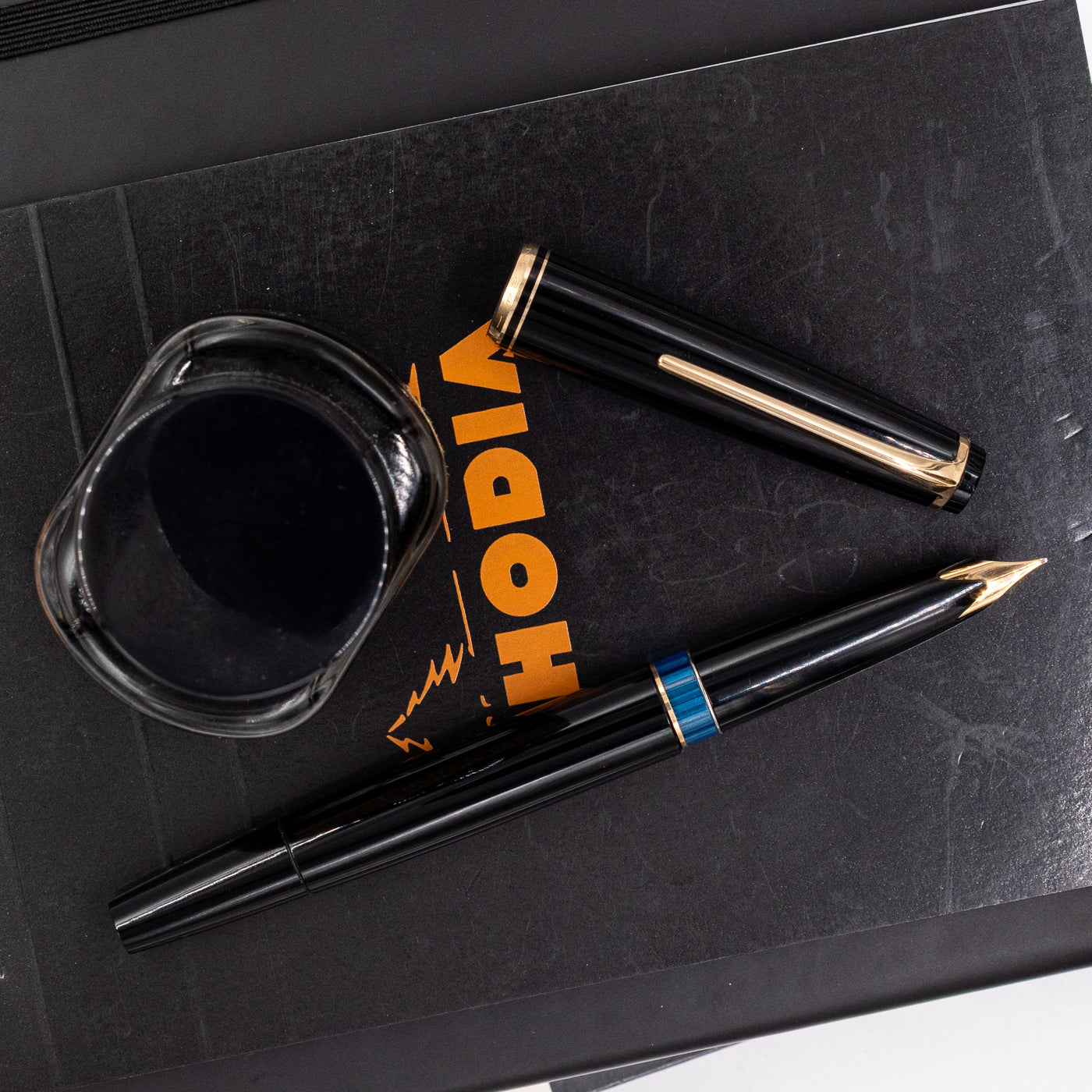 Montblanc No. 24 black fountain pen uncapped with ink bottle and gold-accented cap – vintage German pen with blue ink window