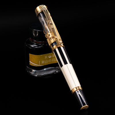 Montblanc Patron of Art Henry Steinway 888 Fountain Pen capped, leaning against an ink bottle. 