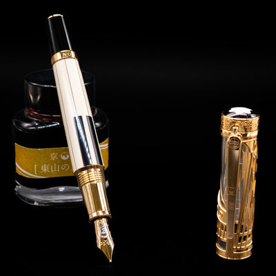 Montblanc Patron of Art Henry Steinway 888 Fountain Pen leaning on an ink bottle uncapped showcasing the detailing on the nib.