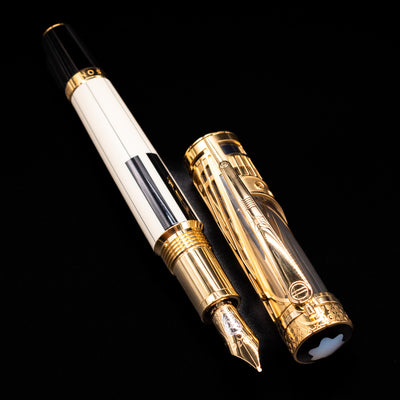 A full view of the Montblanc Patron of Art Henry Steinway 888 Fountain Pen uncapped, with its cap laying next to the pen.