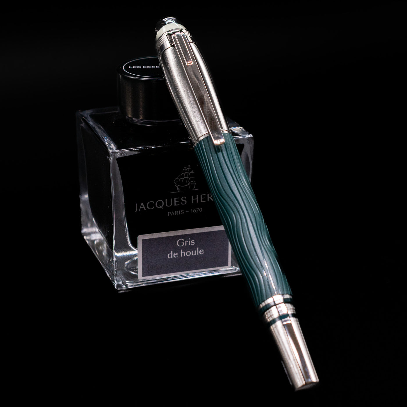 Montblanc Starwalker Doue Fountain Pen - Polar Green capped, leaning against an ink bottle. 