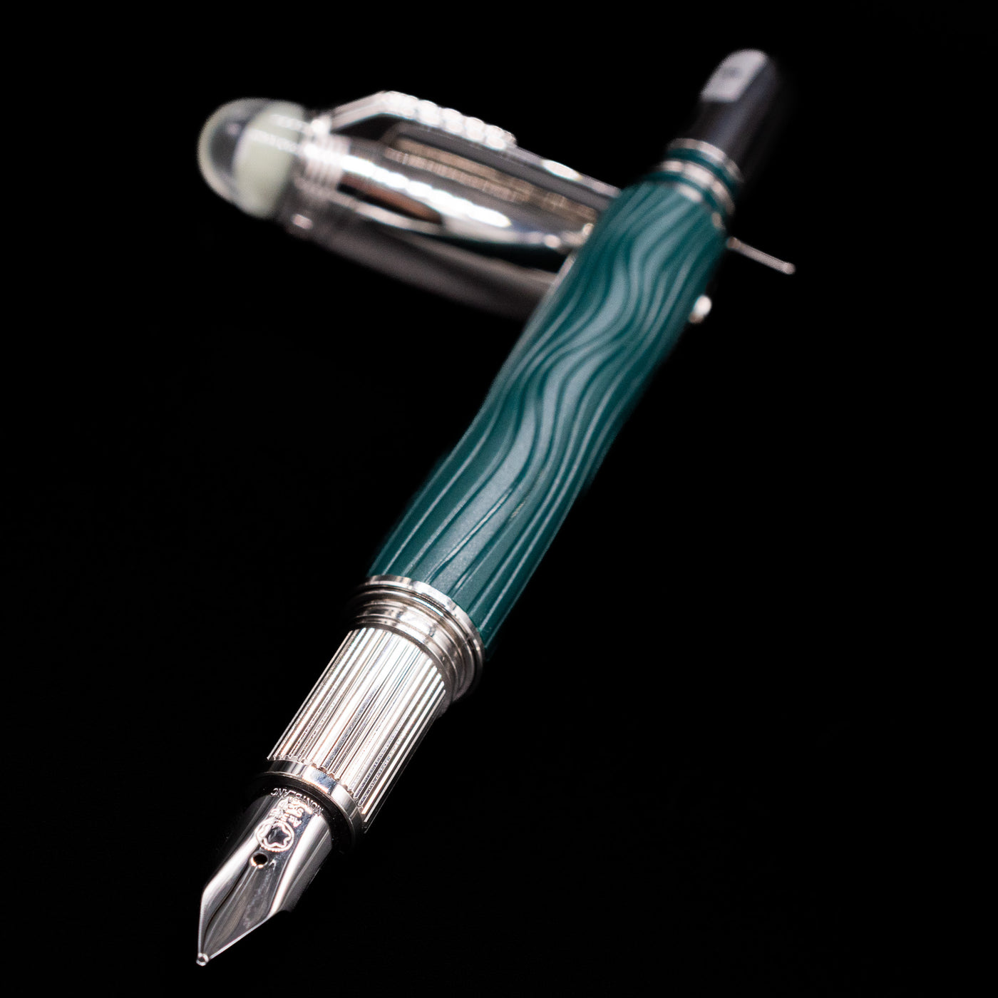 Montblanc Starwalker Doue Fountain Pen - Polar Green laying across its own cap, crossed, with a focus on the nib.