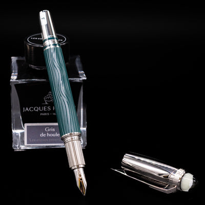 Montblanc Starwalker Doue Fountain Pen - Polar Green leaning on an ink bottle uncapped showcasing the detailing on the nib.