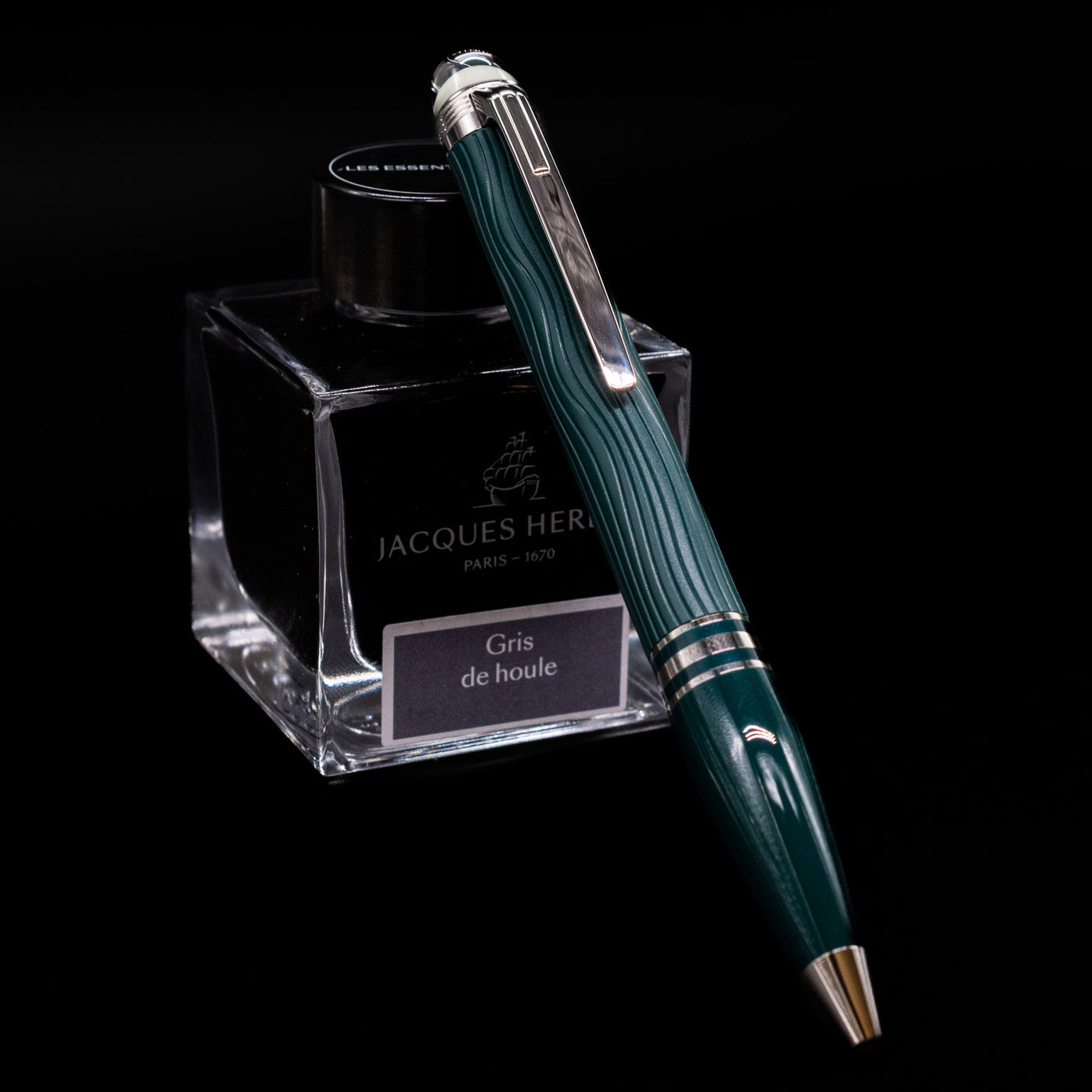 Montblanc Starwalker Resin Ballpoint Pen - Polar Green leaning on an ink bottle.