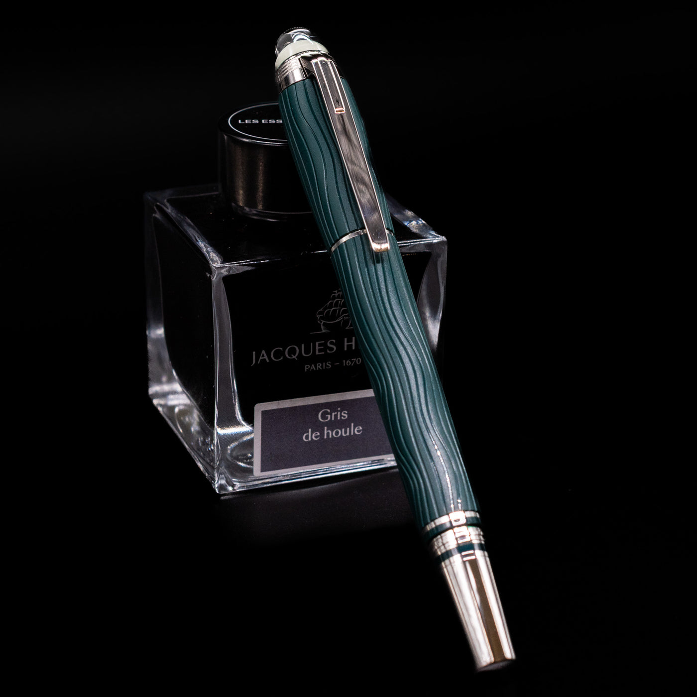 Montblanc Starwalker Resin Fountain Pen - Polar Green capped, leaning against an ink bottle. 