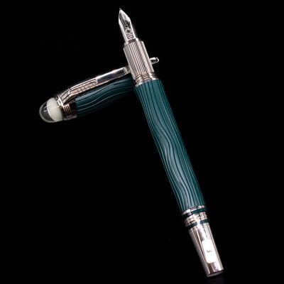Montblanc Starwalker Resin Fountain Pen - Polar Green laying on top of its cap in a crossed position showing full view of the entire uncapped pen.