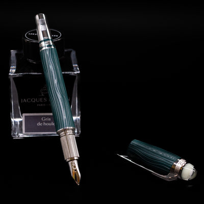 Montblanc Starwalker Resin Fountain Pen - Polar Green leaning on an ink bottle uncapped showcasing the detailing on the nib.