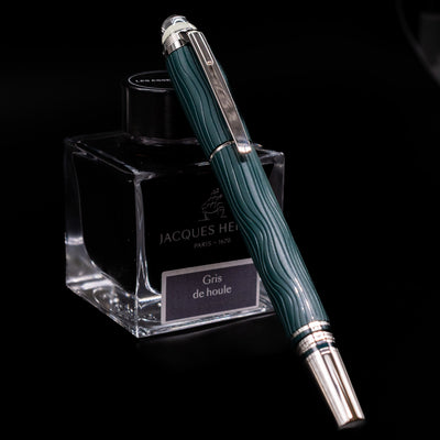 Montblanc Starwalker Resin Rollerball Fineliner Pen - Polar Green capped, leaning against an ink bottle. 