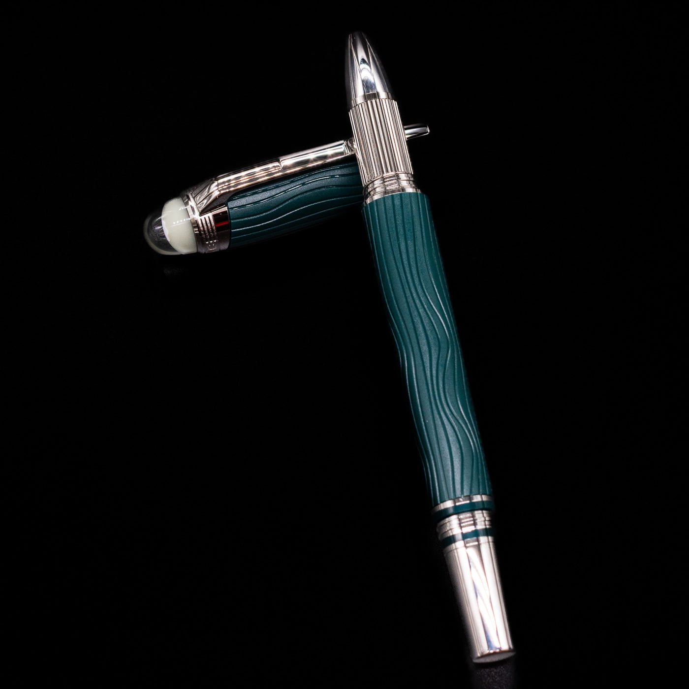 Montblanc Starwalker Resin Rollerball Fineliner Pen - Polar Green laying on top of its cap in a crossed position showing full view of the entire uncapped pen.