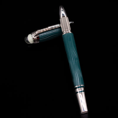 Montblanc Starwalker Resin Rollerball Fineliner Pen - Polar Green laying on top of its cap in a crossed position showing full view of the entire uncapped pen.