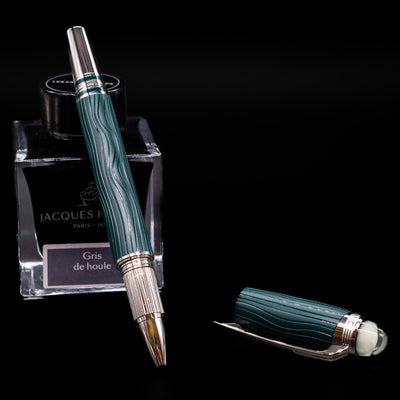 Montblanc Starwalker Resin Rollerball Fineliner Pen - Polar Green leaning on an ink bottle uncapped.
