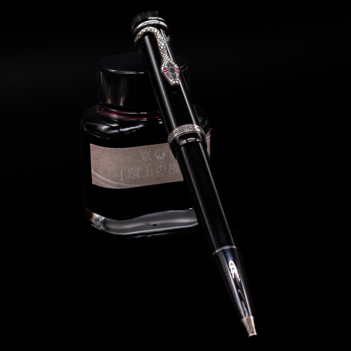 Montblanc Writer's Edition Agatha Christie Ballpoint Pen - Preowned leaning against an ink bottle.
