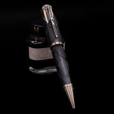 Montblanc Writer's Edition Brothers Grimm Ballpoint Pen - Preowned leaning against an ink bottle.