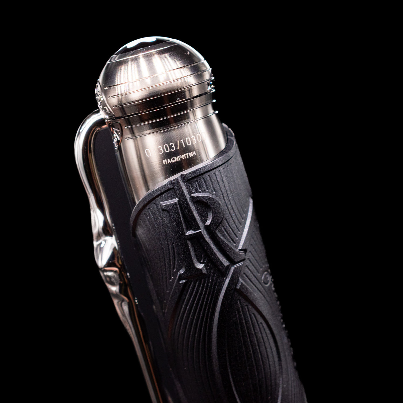 A detail shot of the stylized letter R on the top of the texture black barrel on the Montblanc Writer's Edition Brothers Grimm Ballpoint Pen - Preowned.