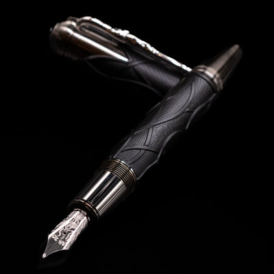 Montblanc Writer's Edition Brothers Grimm Fountain Pen laying across its own cap, crossed, with a focus on the nib.