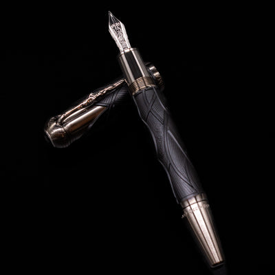 Montblanc Writer's Edition Brothers Grimm Fountain Pen laying on top of its cap in a crossed position showing full view of the entire uncapped pen.