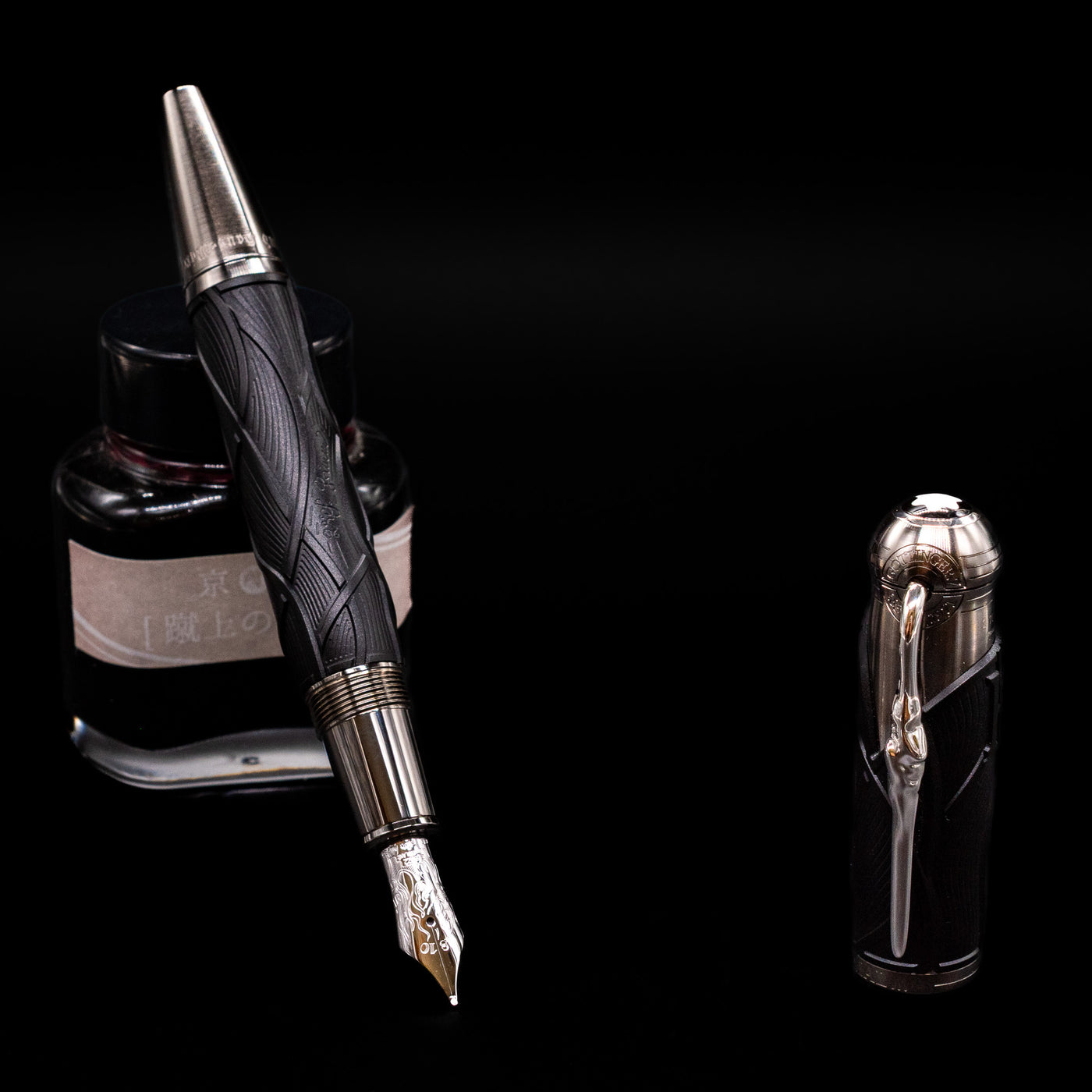 Montblanc Writer's Edition Brothers Grimm Fountain Pen leaning on an ink bottle uncapped showcasing the detailing on the nib.