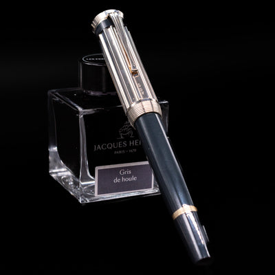 Montblanc Writer's Edition Charles Dickens Fountain Pen - Preowned capped, leaning against an ink bottle.