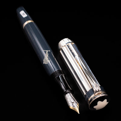 A full view of the Montblanc Writer's Edition Charles Dickens Fountain Pen - Preowned uncapped, with its cap laying next to the pen. 