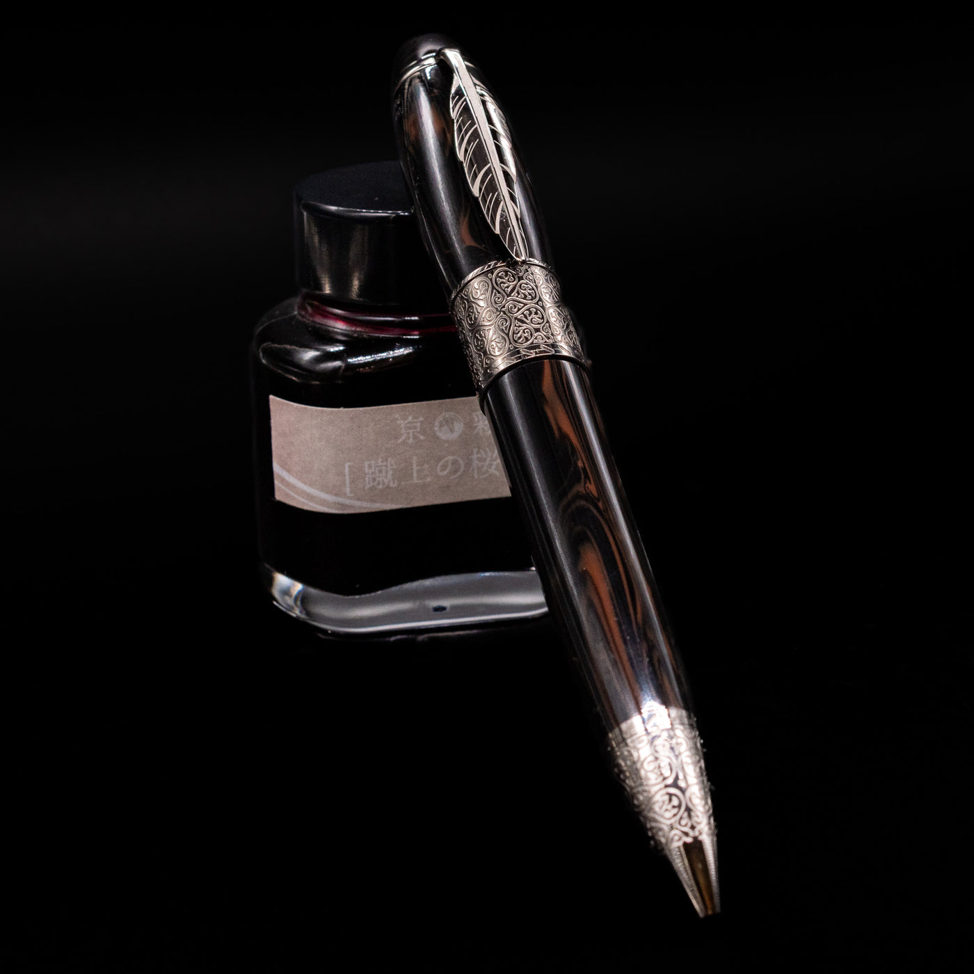 Montblanc Writer's Edition Daniel Defoe Ballpoint Pen - Preowned leaning against an ink bottle.