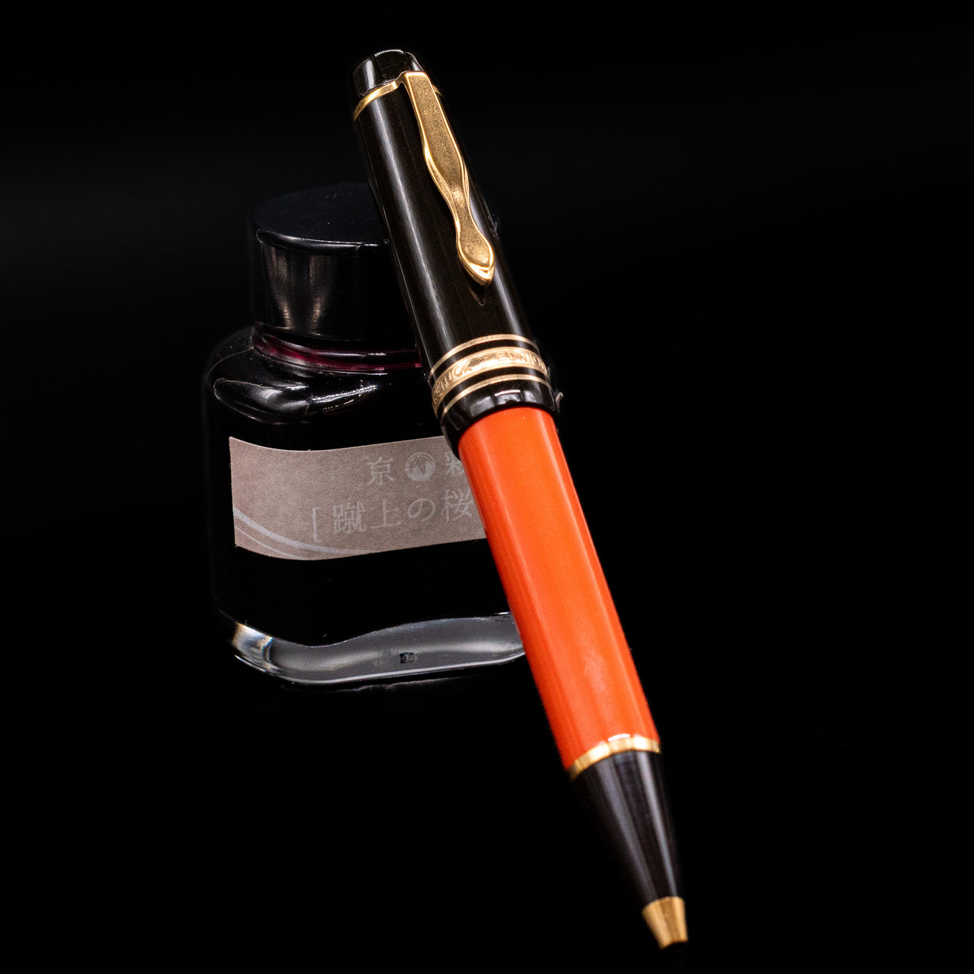 Montblanc Writer's Edition Ernest Hemingway Ballpoint Pen - Preowned leaning against an ink bottle.