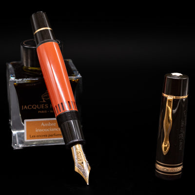 Montblanc Writer's Edition Ernest Hemingway Fountain Pen - Preowned  leaning on an ink bottle uncapped showcasing the detailing on the nib.