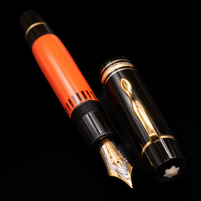 A full view of the Montblanc Writer's Edition Ernest Hemingway Fountain Pen - Preowned uncapped, with its cap laying next to the pen. 