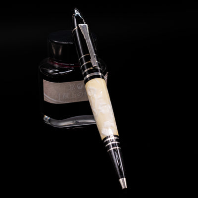 Montblanc Writer's Edition F Scott Fitzgerald Ballpoint Pen - Preowned leaning on an ink bottle.