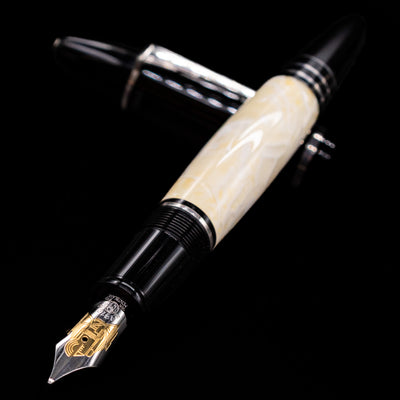Montblanc Writer's Edition F. Scott Fitzgerald Fountain Pen - Preowned laying across its own cap, crossed, with a focus on the nib.