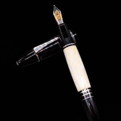 Montblanc Writer's Edition F. Scott Fitzgerald Fountain Pen - Preowned  laying on top of its cap in a crossed position showing full view of the entire uncapped pen.