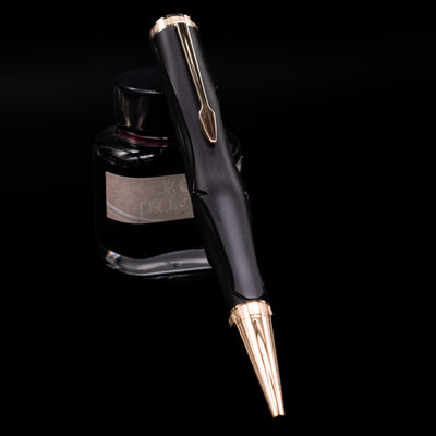Montblanc Writer's Edition Homer Ballpoint Pen - Preowned leaning against an ink bottle.