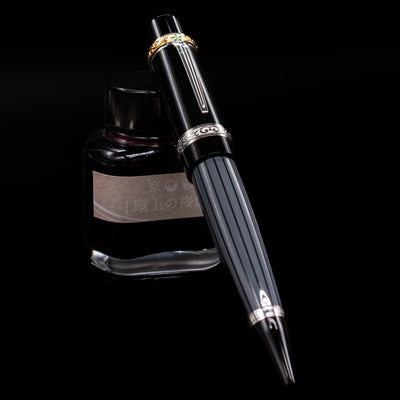 Montblanc Writer's Edition Honore de Balzac Ballpoint Pen - Preowned leaning against an ink bottle.